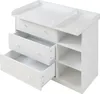 A white changing table with drawers and shelves, shown from a slightly elevated side angle. Podgląd zdjęcia produktu