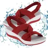Paar roter Keilabsatz-Sandalen mit Schleifendetail am Riemen, weiße Sohle und roter Rand, umgeben von Wasserspritzern Náhled obrázku produktu