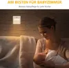 A mother is holding her baby in a dimly lit room, with a night light on the wall. Náhled obrázku produktu