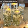 Three glass vases filled with baby's breath flowers and water, each with a floating LED candle. Produktbild-Vorschau