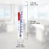 A thermometer hanging against a blurred background of an indoor space. Produktbild-Vorschau