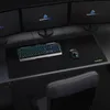 A gaming setup with a keyboard, mouse, and mousepad on a desk, with multiple monitors in the background. Produktbild-Vorschau