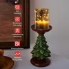 A decorative LED candle holder shaped like a Christmas tree, with a glass cylinder containing fairy lights and a candle. Produktbild-Vorschau