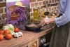 A person is cooking in a kitchen with a decorative panel in the background. Náhled obrázku produktu
