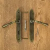 Door handles and related hardware laid out on a wooden surface. Produktbild-Vorschau