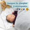 A baby sleeping under a blanket with a teddy bear nearby. Produktbild-Vorschau