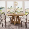 A round wooden dining table with chairs in a well-lit room with large windows overlooking a suburban landscape. Anteprima dell’immagine prodotto