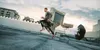 A man is running on a rooftop with a parachute attached to him. Náhled obrázku produktu