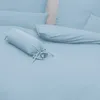 A close-up view of light blue bedding, including a bolster pillow. Produktbild-Vorschau