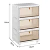 A white, three-drawer storage cabinet with translucent tan drawers, shown with dimensions indicated by measurement lines and text. Voir les images du produit