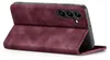 A burgundy flip case for a smartphone is shown partially open, revealing the phone's camera module. Produktbild-Vorschau