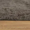 A close-up view of a shaggy rug on a wooden floor. Anteprima dell’immagine prodotto