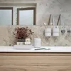 A bathroom sink area with a toothbrush holder, soap dispenser, and a small plant. Produktbild-Vorschau