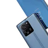 A close-up view of a blue smartphone with a silver camera module and a blue flip case with a clock display. Náhled obrázku produktu