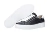 A pair of black leather sneakers with white laces and soles, shown from a diagonal angle with one shoe lying on its side to reveal the sole. Produktbild-Vorschau