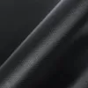 A close-up, angled view of a black, textured fabric, likely a grill mat, with a subtle sheen. Produktbild-Vorschau