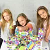 Three young girls are playing with colorful building blocks. Podgląd zdjęcia produktu