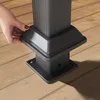 A hand is shown adjusting the base of a dark gray gazebo post on a wooden deck. Produktbild-Vorschau