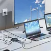 A desk setup with a large monitor, two laptops, a router, and a network switch connected by cables. Produktbild-Vorschau
