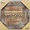 The image shows the top view of a Monopoly board game box with a wooden design. Produktbild-Vorschau