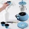 A collection of Japanese tea set items, including a teapot, cups, a strainer, and a lid, arranged on a white surface with a vase and flowers. Náhled obrázku produktu