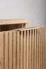 A close-up shot of a wooden cabinet with a fluted design and a gold handle. Anteprima dell’immagine prodotto
