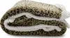 A folded leopard print blanket with a white sherpa lining. Produktbild-Vorschau