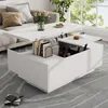 A white lift-top coffee table is shown in a living room setting, with books and a vase of flowers on top. Produktbild-Vorschau