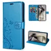 A collage of images showing a blue flip-style phone case with a floral and butterfly embossed design, including views of the case open with cards inserted and the phone inside. Produktbild-Vorschau