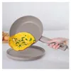 A hand is holding a frying pan with an omelet being slid onto a plate. Anteprima dell’immagine prodotto