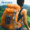 A person with a backpack in a natural setting, with a power bank attached to the backpack. Produktbild-Vorschau