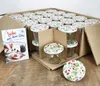 A cardboard box filled with jars, with a recipe book next to it. Voir les images du produit