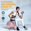 A woman is exercising with a pink exercise ball and dumbbells. Anteprima dell’immagine prodotto