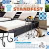 A decorative outdoor table with a bowl of fruit on a patio with lounge chairs and a cat. Produktbild-Vorschau