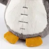 A close-up view of the lower body and feet of a plush toy penguin. Produktbild-Vorschau