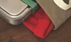 A close-up shot of a stainless steel lunch box with a green lid and a red knitted item peeking out of a brown canvas bag, all resting on a wooden surface. Podgląd zdjęcia produktu