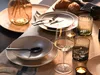 A table setting with plates, bowls, cutlery, glasses, and bread. Náhľad obrázku produktu