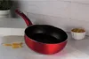 A red frying pan is displayed on a countertop with some pasta in a bowl and some uncooked pasta on the side. Produktbild-Vorschau