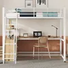 A white metal loft bed with a desk and shelves underneath, set up in a room with a chair and a laptop on the desk. Produktbild-Vorschau