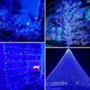 A collage of four images showcasing blue LED string lights in various settings, including a garden with a skeleton decoration, a tree wrapped in lights, a shelf decorated with lights, and a large conical structure covered in lights. Produktbild-Vorschau