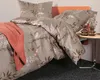 A neatly made bed with a floral patterned duvet cover and a coral throw blanket. Produktbild-Vorschau