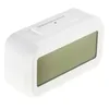 A white digital alarm clock with a large LCD screen and a snooze/light button on top. Náhled obrázku produktu