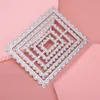A set of nested, diamond-shaped metal cutting dies with a perforated edge, laid diagonally on a pink surface. Náhled obrázku produktu