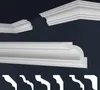 A collection of white decorative molding profiles against a dark blue background, showcasing different styles and angles. Produktbild-Vorschau