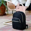 A person is placing a pink laptop sleeve into a black backpack. Anteprima dell’immagine prodotto
