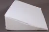 A white wedge pillow on a gray background. Náhled obrázku produktu