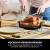 A roasted chicken with vegetables is being carved in a glass dish on a table set for a meal. Anteprima dell’immagine prodotto