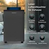 A dark gray humidifier with blue light on top, placed on a floor with a blurred background of a room. Produktbild-Vorschau