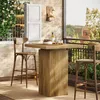 A bar table and two stools on a balcony with a view of buildings and greenery. Produktbild-Vorschau
