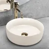 A close-up shot of a white ceramic vessel sink with a gold faucet. Náhľad obrázku produktu